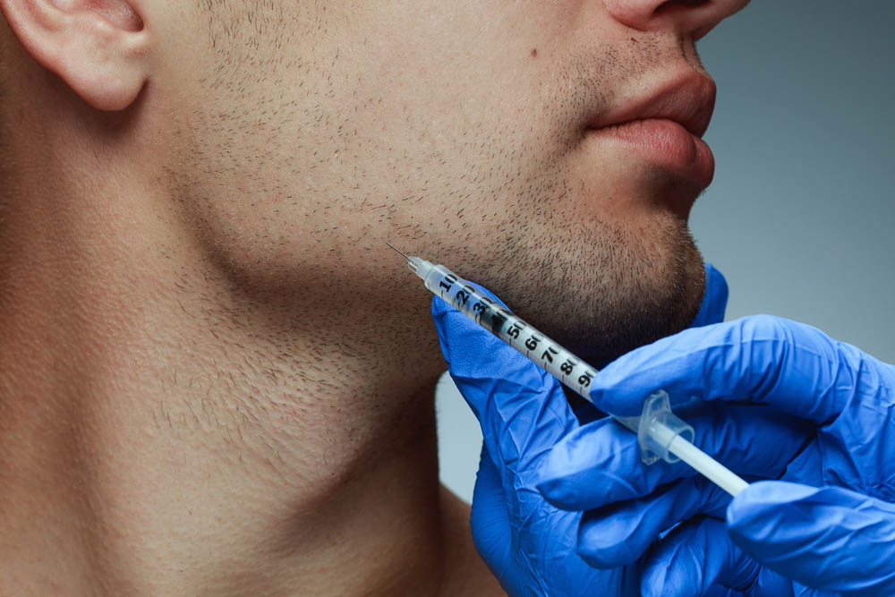 Botox syringe held next to masseters