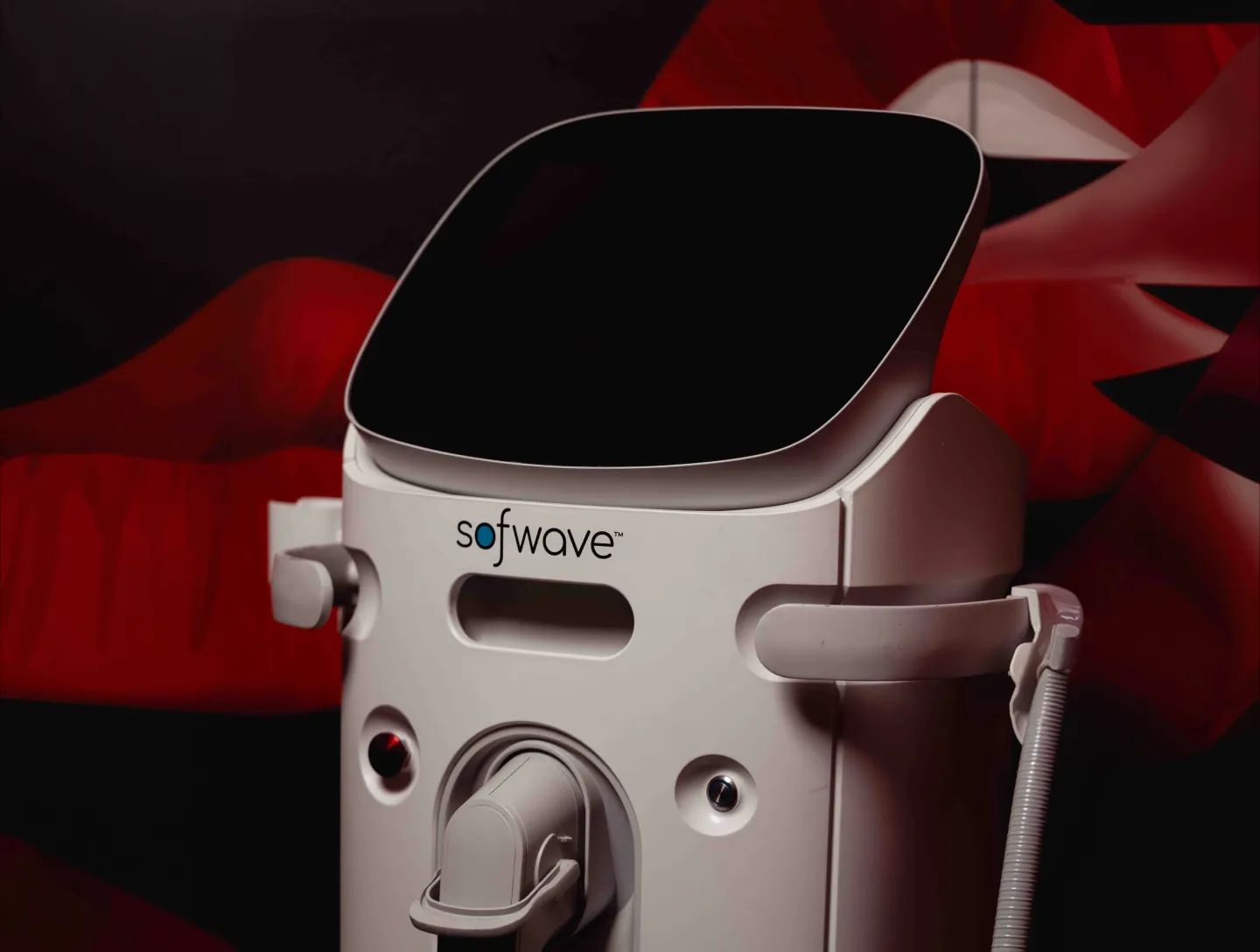 A Sofwave device in front of the red lips mural