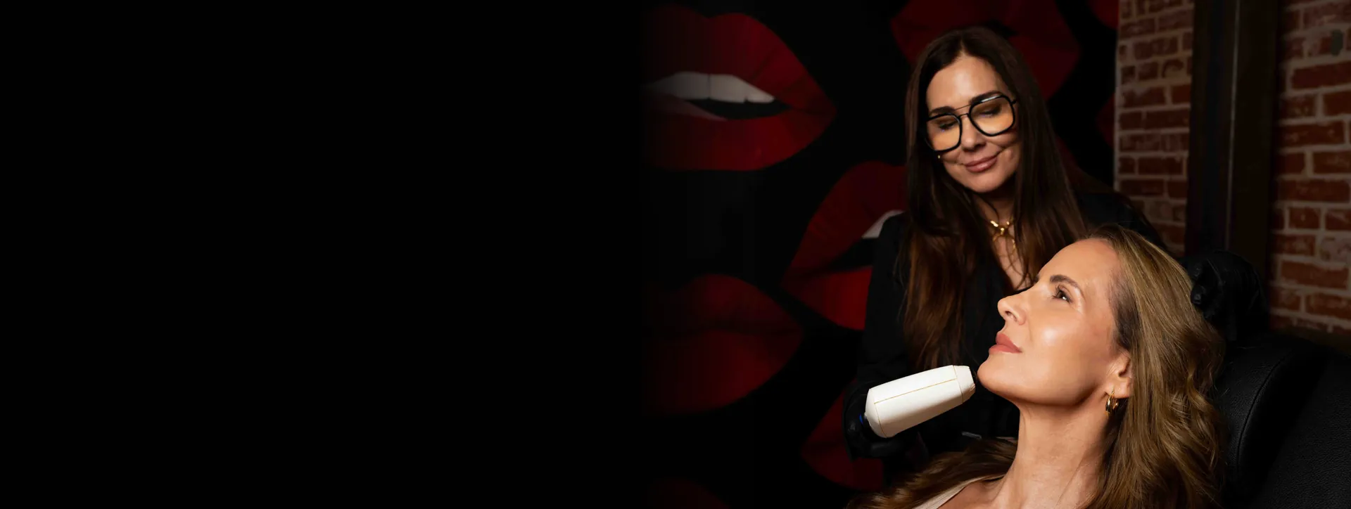 Rewind provider performing a skin treatment on a smiling patient in front of a red lips mural